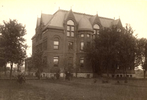 Black & White photograph showing the Hall of Science as it looked in 1902. Small trees are growing on the campus grounds.